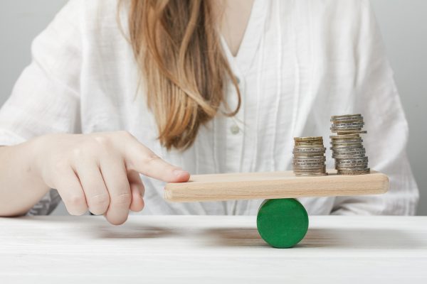 woman-holding-her-finger-balance-with-coins
